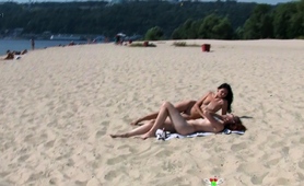 nudist-teen-with-brown-hair-is-sitting-down-on-the-beach